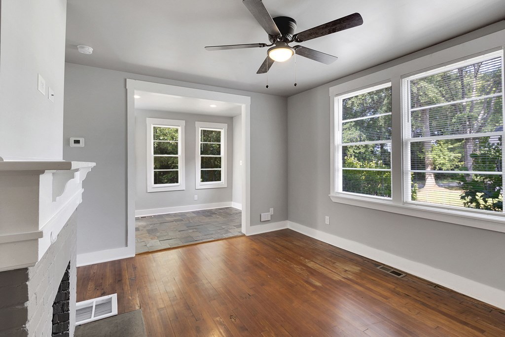 A room with a fireplace and a ceiling fan.