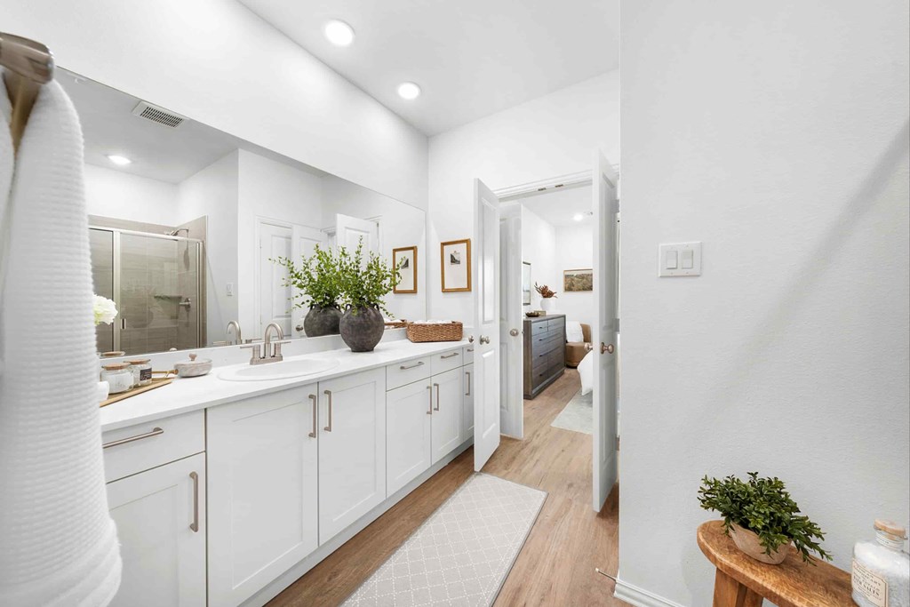 A white bathroom with a white sink and a white towel hanging on the wall.