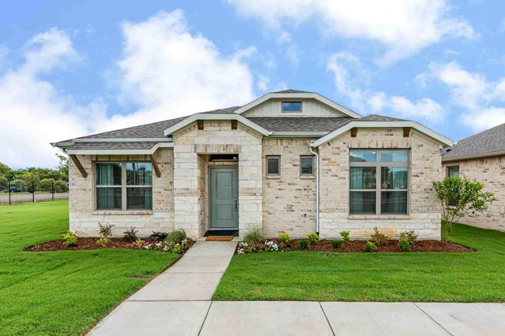A house with a green lawn in front.