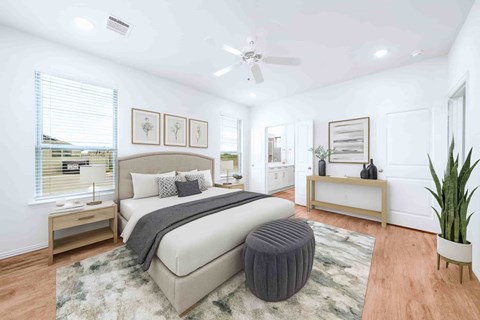 A bedroom with a large bed and a ceiling fan.