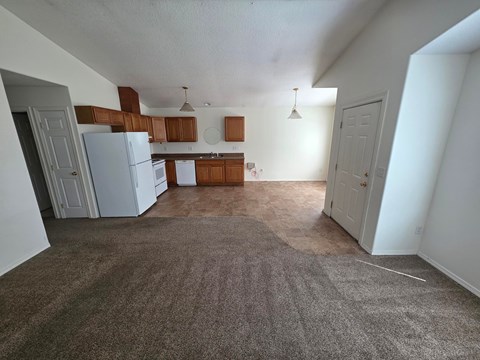 A kitchen with white appliances and brown cabinets.
