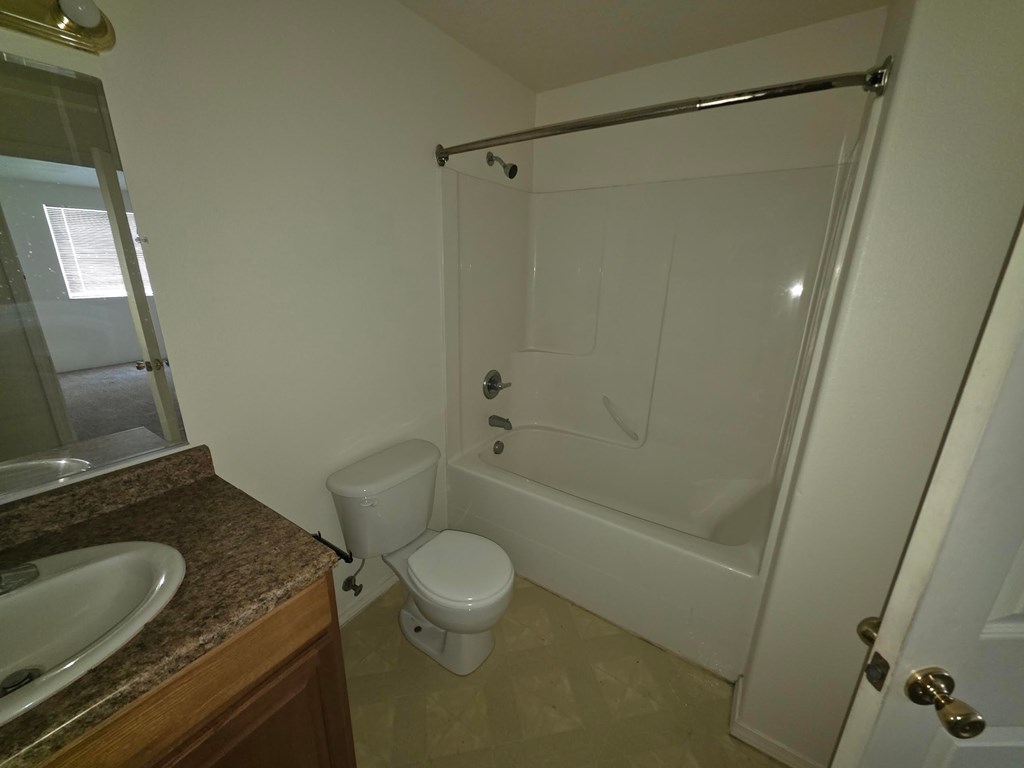 A white toilet sits next to a sink in a small bathroom.