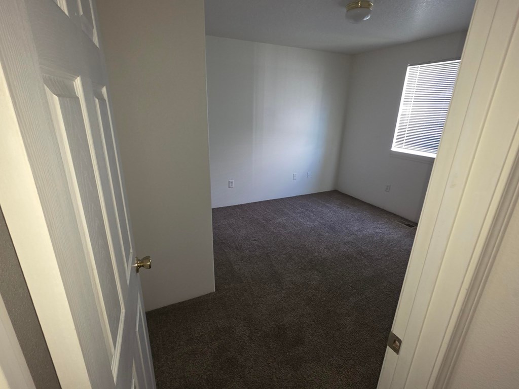 A room with a carpeted floor and white walls.