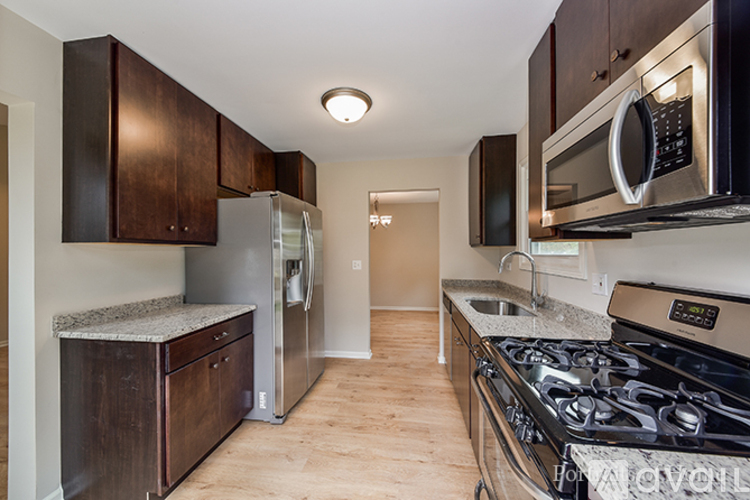 A kitchen with a stove top oven and a microwave above it.