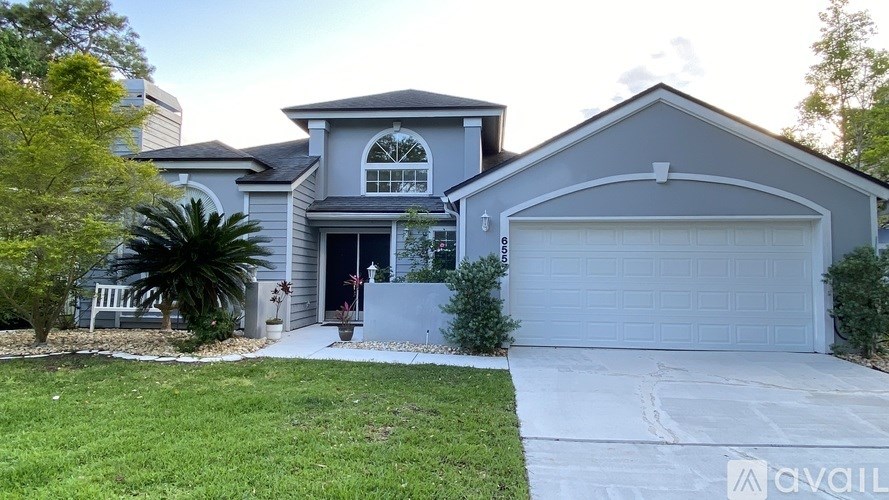 A house with a garage and a driveway in front of it.