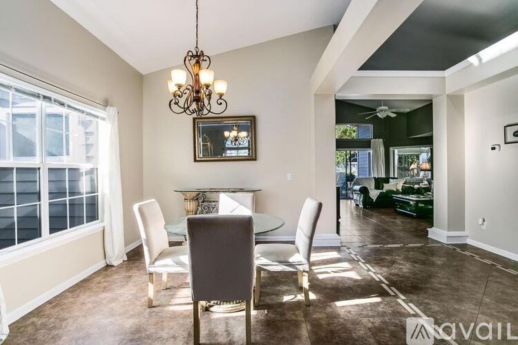 A dining room with a table and chairs.