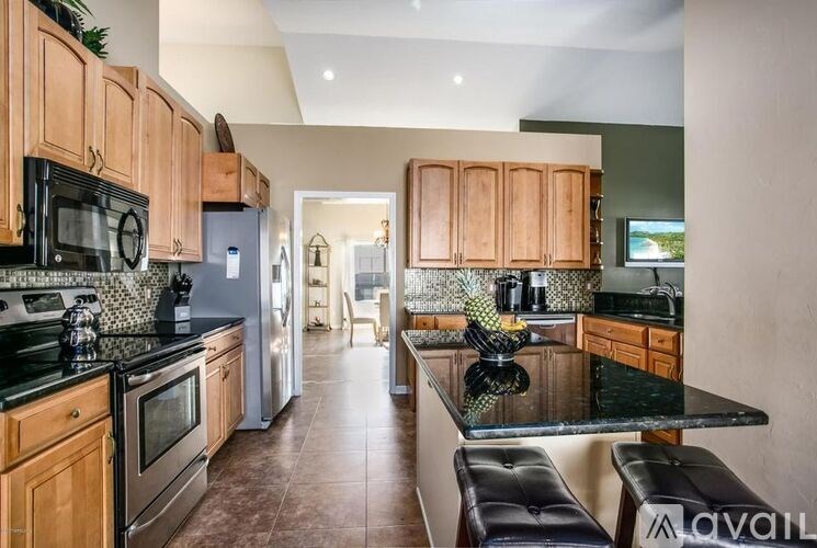 A kitchen with wooden cabinets and black countertops.