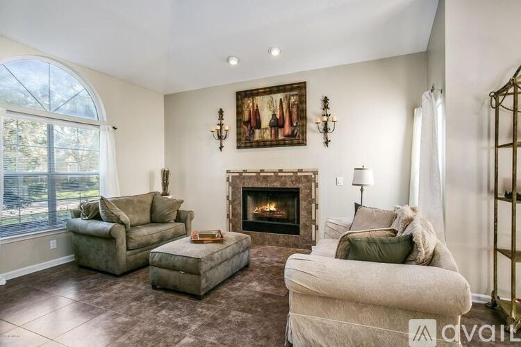 A living room with a fireplace and a painting on the wall.