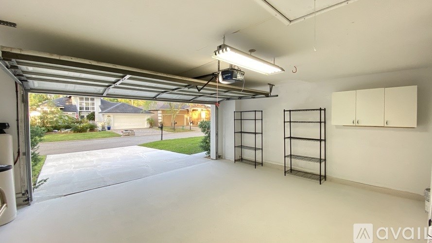 A spacious garage with a view of a residential area outside.