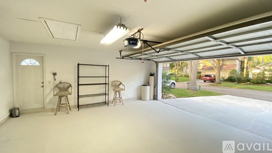 A garage with a white interior and a view of a street outside.