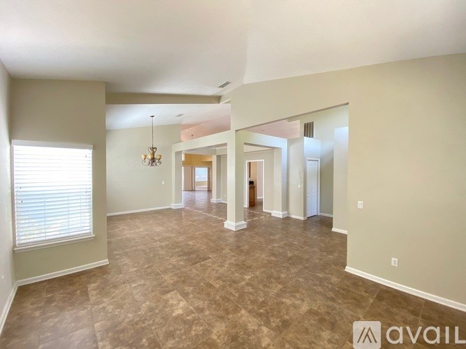 A spacious room with a large mirror and a chandelier.
