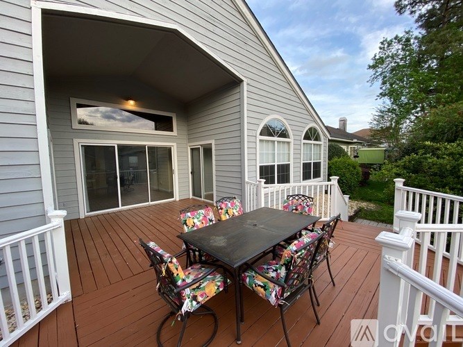 A patio with a table and chairs is set up on a deck.