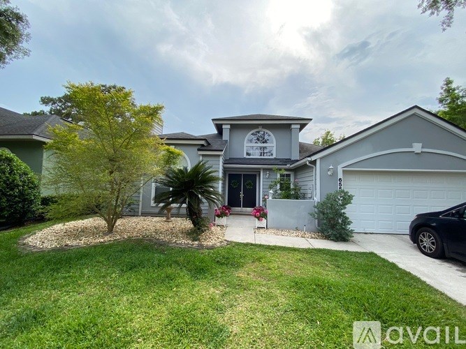A house with a front yard and a tree.