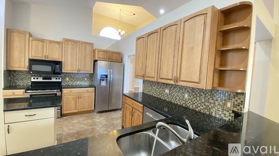 A kitchen with wooden cabinets and black countertops.