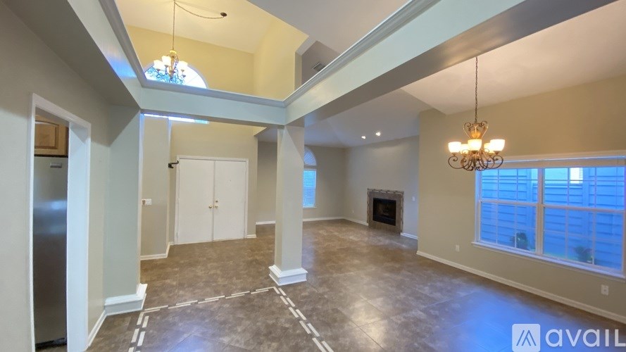A spacious living room with a chandelier and a fireplace.