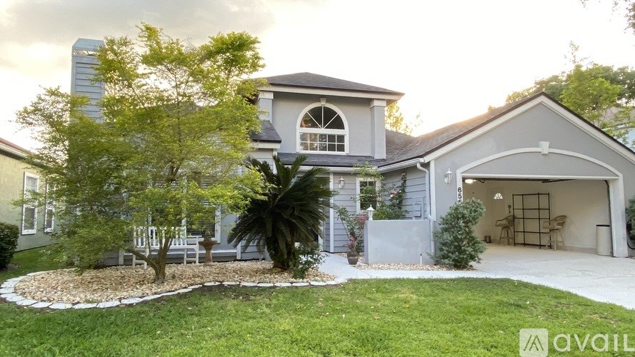 A house with a grey roof and a white garage is for sale.