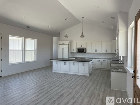 A spacious kitchen with white cabinets and a central island.