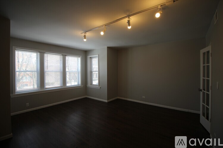 A room with a window and wooden flooring.