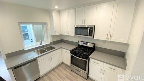 A kitchen with white cabinets and stainless steel appliances.