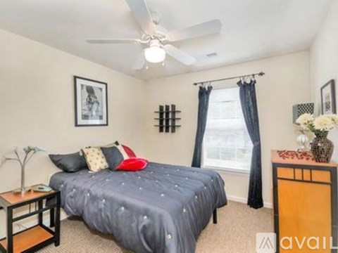 A bedroom with a bed, nightstand, and window.