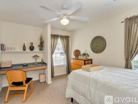 A bedroom with a bed, desk, and chair.