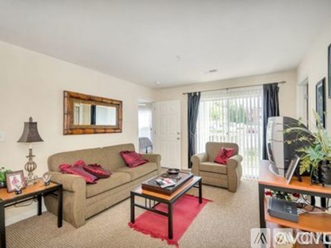 A living room with a couch, chair, and coffee table.