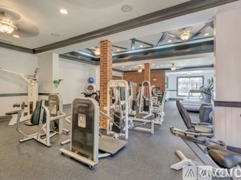A well-equipped gym with various exercise machines and weights.