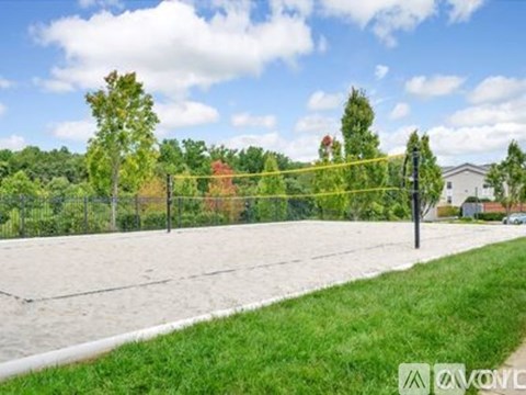 A tennis court surrounded by a fence and trees.