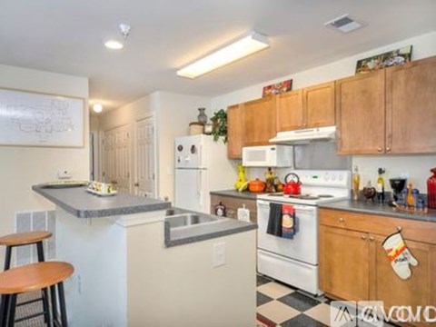 A kitchen with white appliances and wooden cabinets.