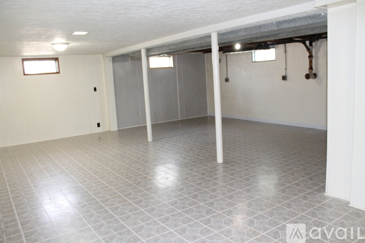 A spacious room with tile flooring and white walls.