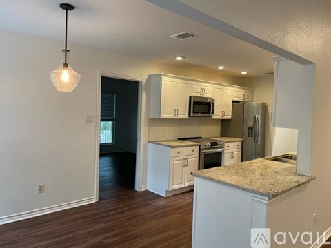 A kitchen with white cabinets and a granite countertop.