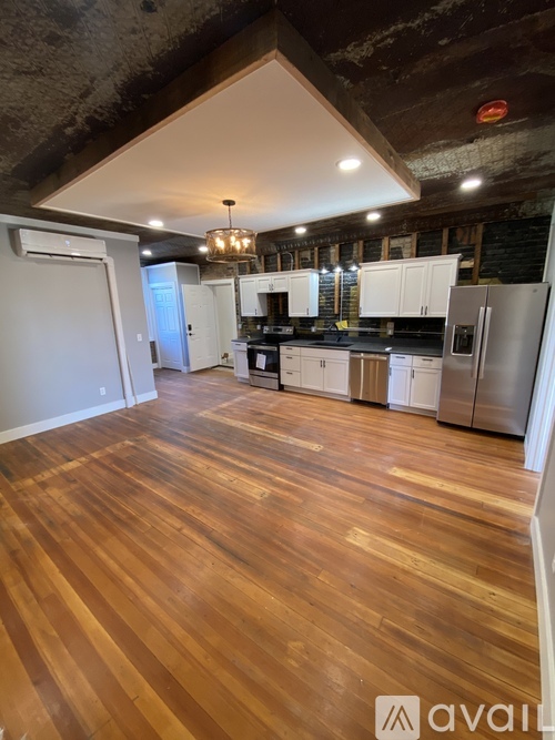 A kitchen with wooden floors and stainless steel appliances.