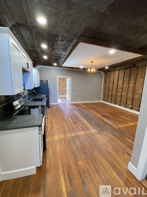 A kitchen with wooden floors and white cabinets is available for rent.