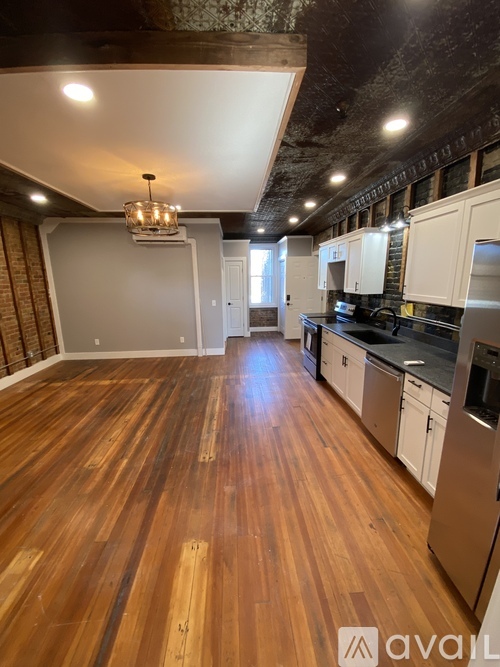 A kitchen with wooden floors and a chandelier.
