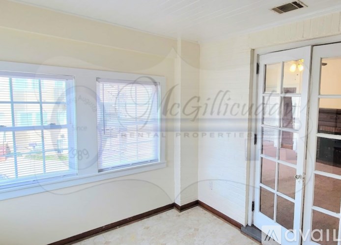A room with a window and a door leading to a balcony.