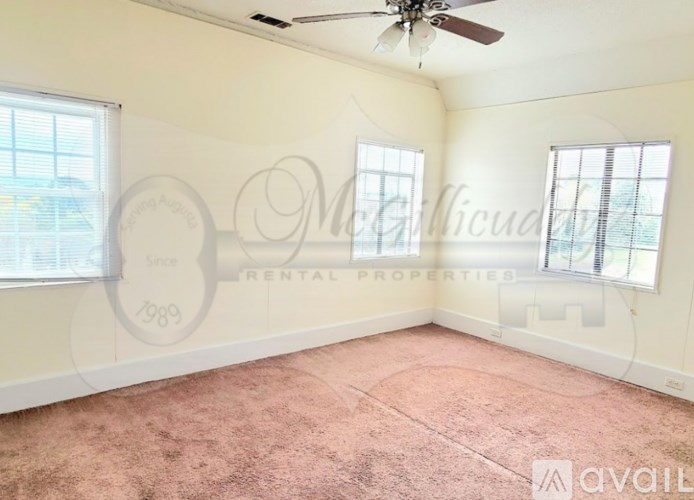 A room with a ceiling fan and two windows.