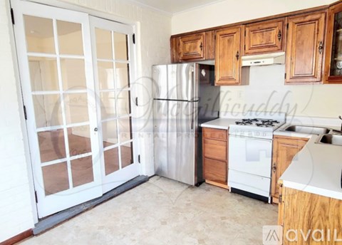 A kitchen with a white fridge, wooden cabinets, and a white stove top oven.