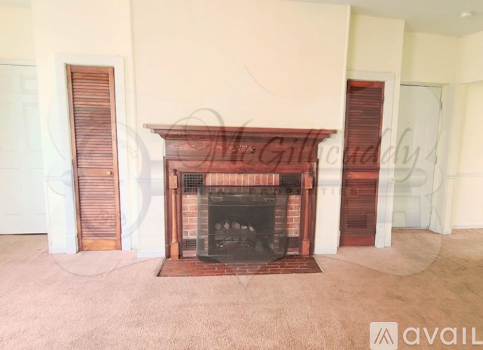 A fireplace in a room with a carpeted floor.