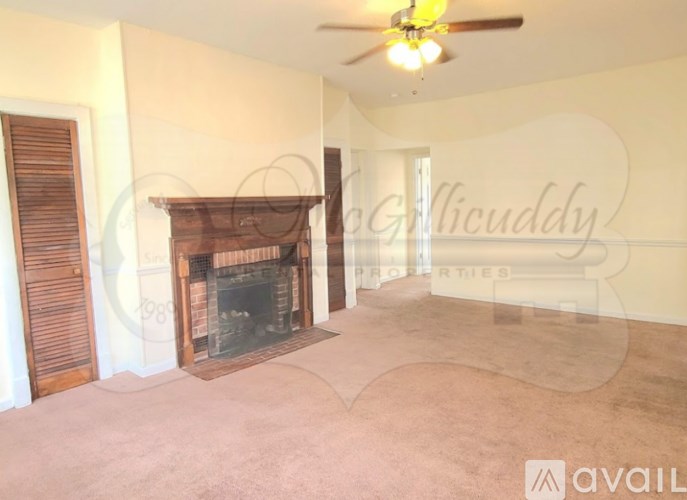 A living room with a fireplace and a ceiling fan.