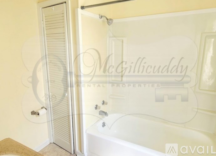 A white bathtub with a shower head and a towel rack.