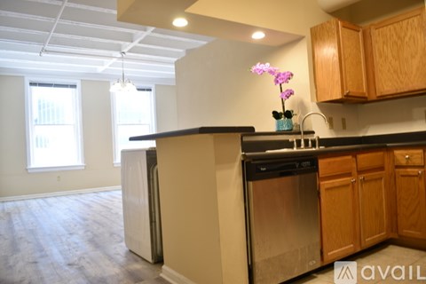 A kitchen with wooden cabinets and a black countertop.