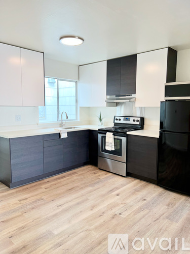 A kitchen with a black refrigerator, stove, and oven.