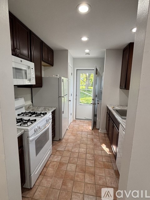 A kitchen with a white stove and brown cabinets.
