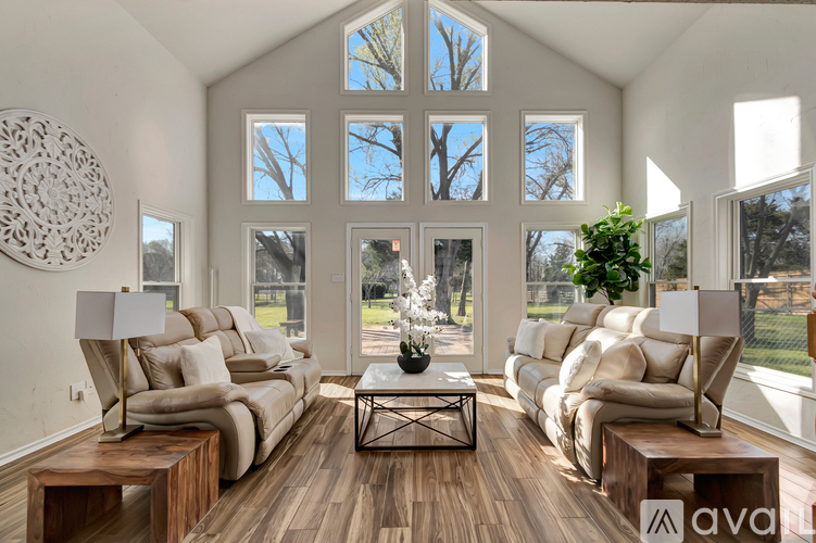 A living room with a large window and a wooden floor.