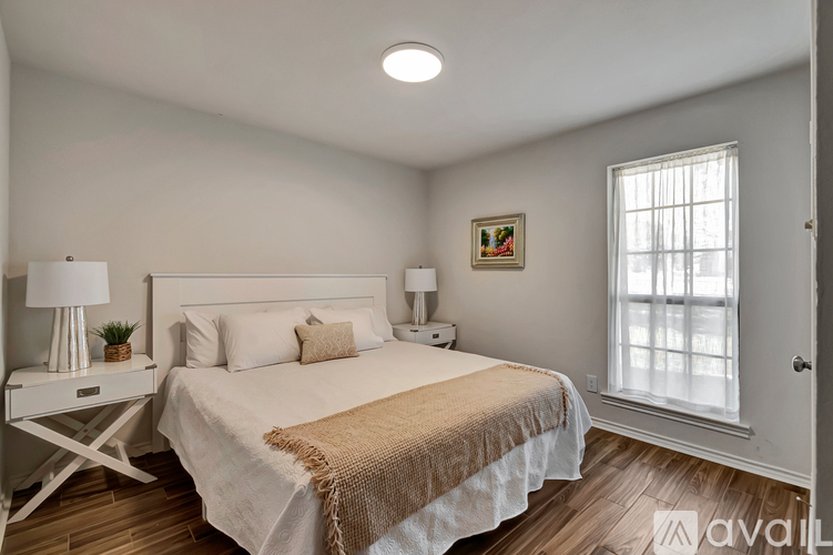 A bedroom with a large bed and a window.
