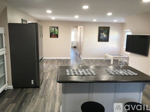 A black refrigerator is in a kitchen with a black counter top.