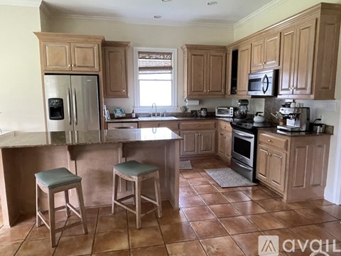 A kitchen with wooden cabinets and a tile floor.