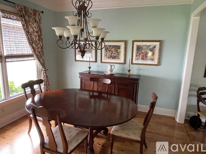 A dining room with a table and chairs.