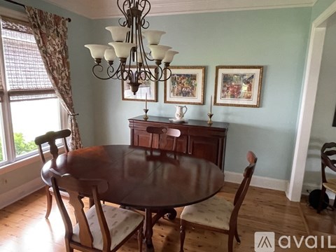 A dining room with a table and chairs.