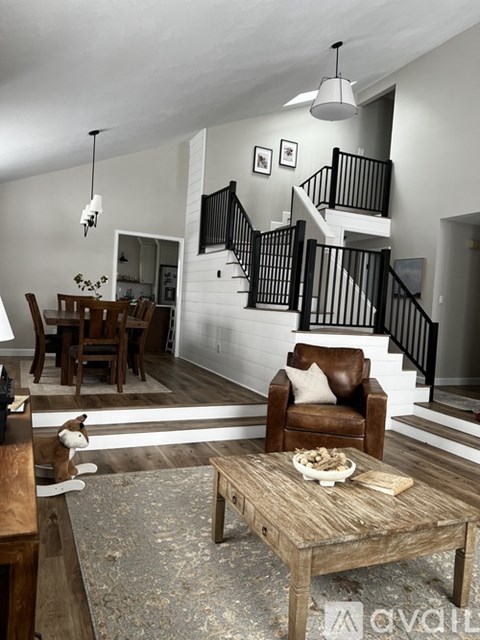 A dog sits on a rug in a living room with a wooden coffee table.
